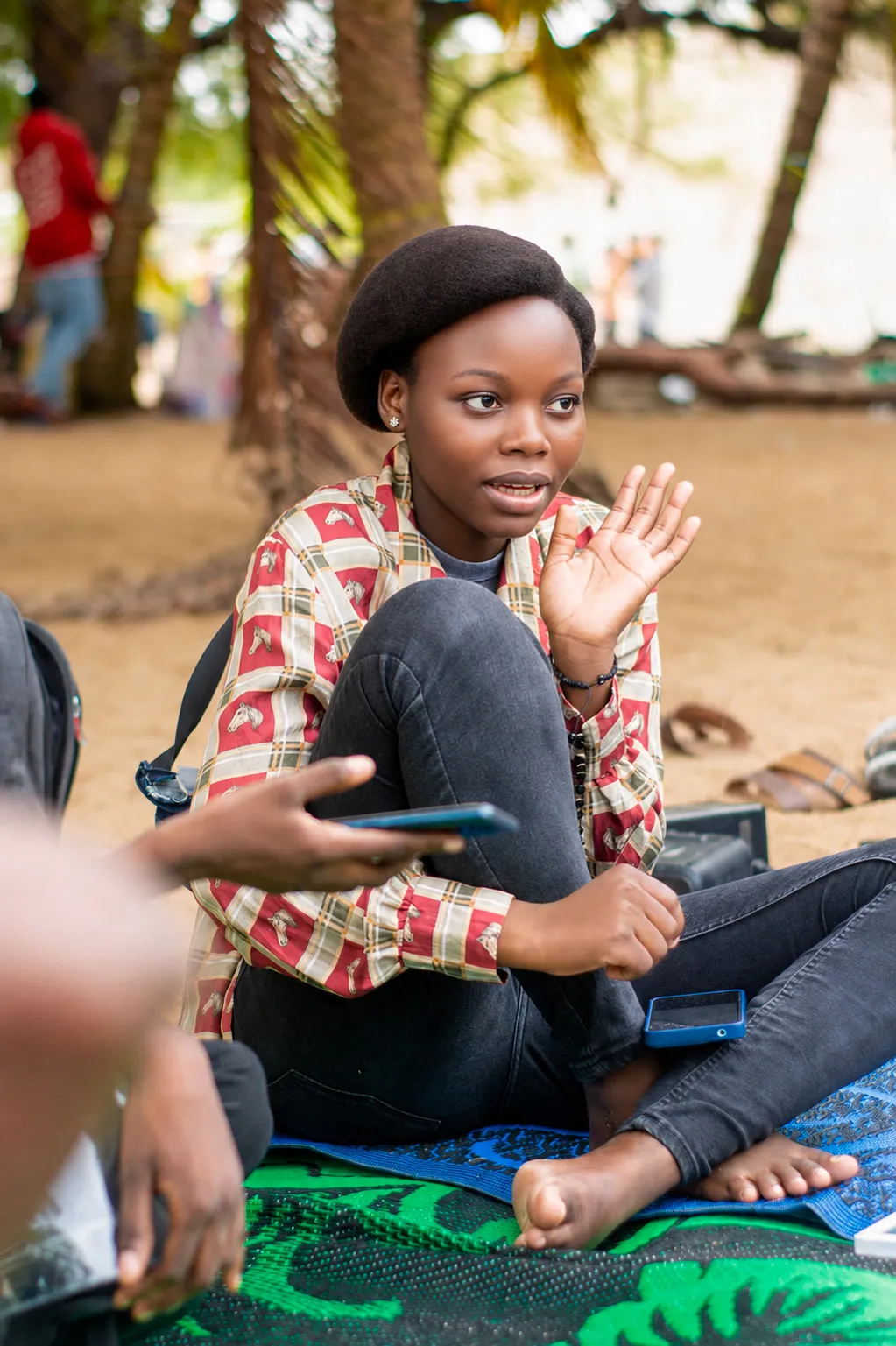 Un groupe de jeunes souriants, regardant ensemble un téléphone.