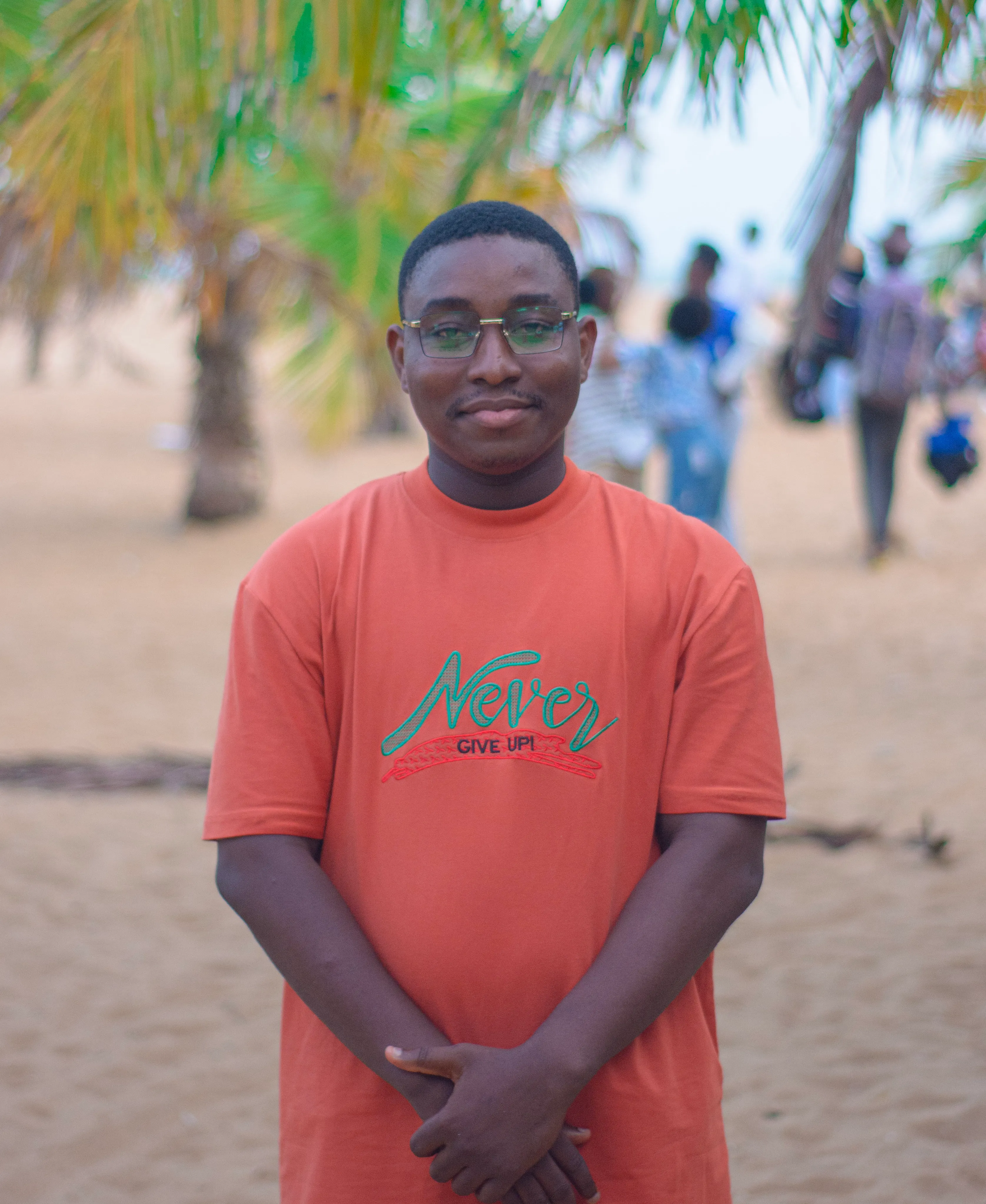 Portrait rapproché d'un jeune homme souriant en extérieur.