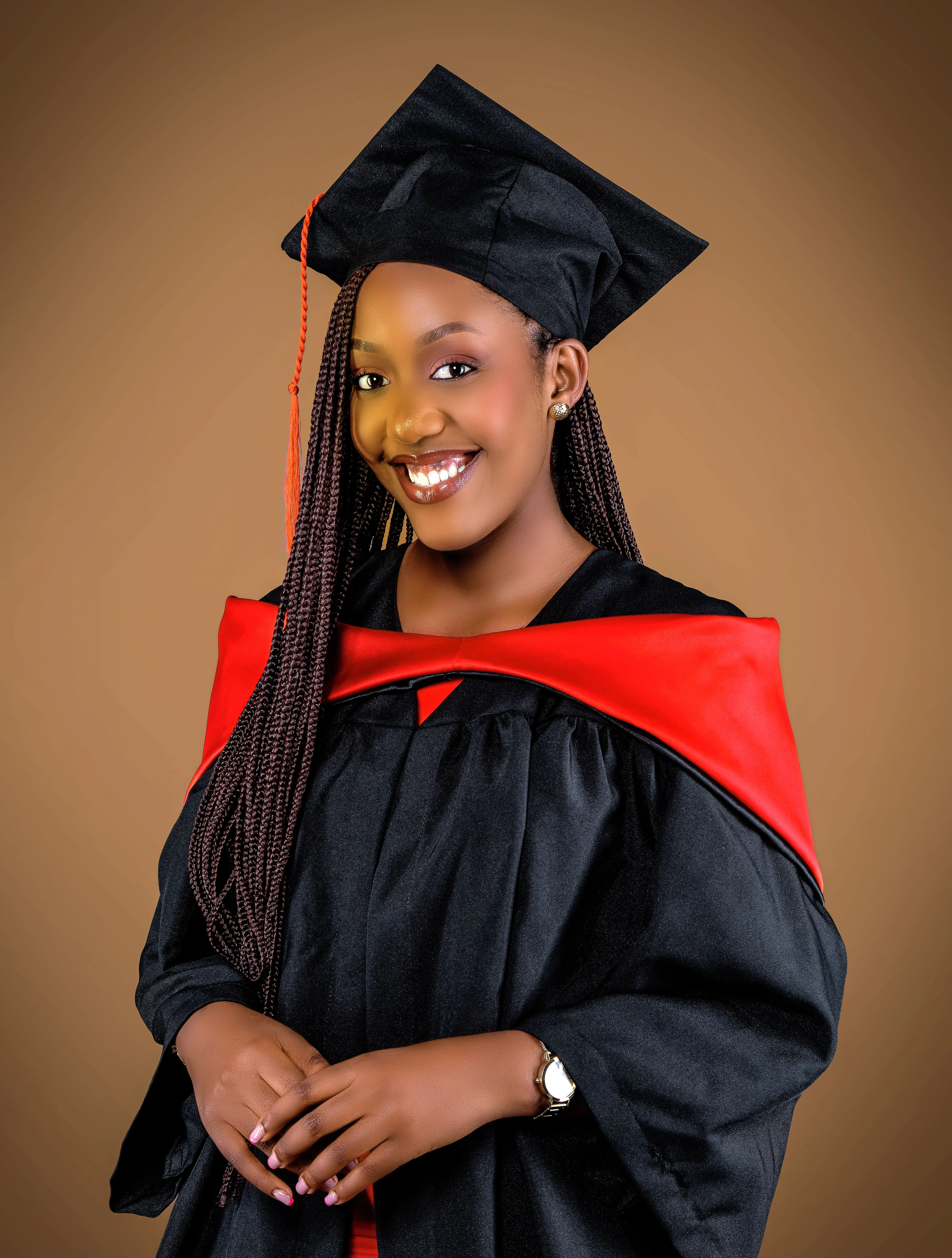 Une jeune diplômée en toge et toque, fière de son parcours académique.