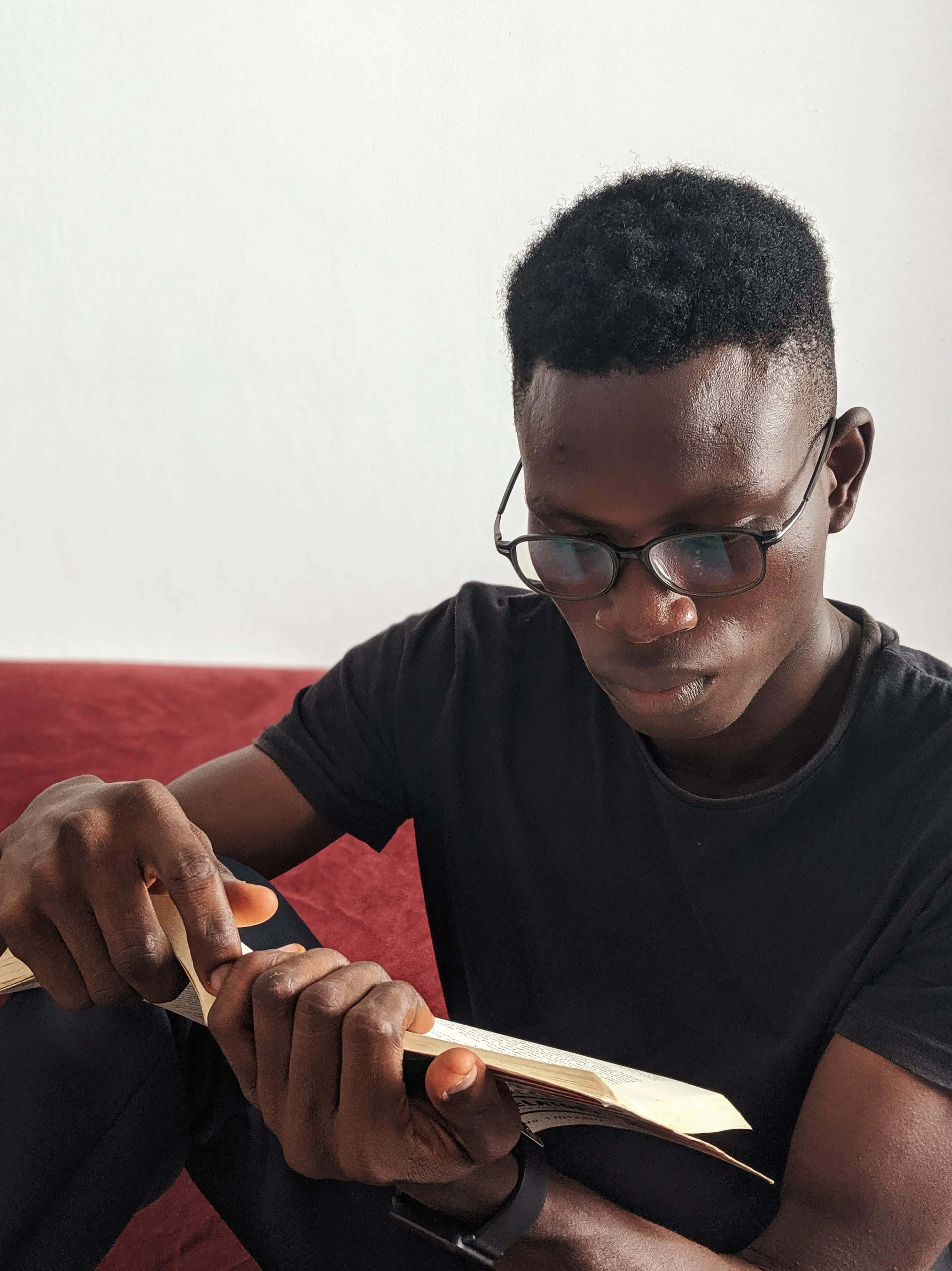 Un jeune homme lisant la Bible, plongé dans un moment calme de lecture et de réflexion.